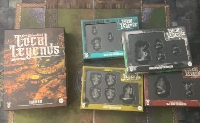 A photo of the Epic Encounters: Local Legends Tavern Kit and four encounter boxes sitting on a gaming mat.
