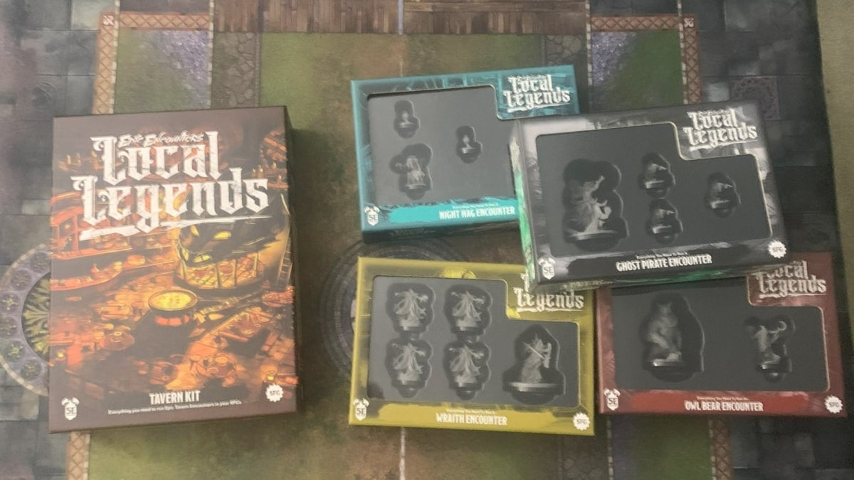 A photo of the Epic Encounters: Local Legends Tavern Kit and four encounter boxes sitting on a gaming mat.